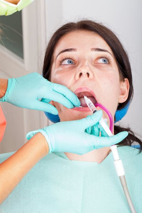 A close-up picture of a female dentist using dental instruments to take a picture of her patient teeth cavity during a dental procedure. Dental care and professional dental technology concept. Close up picture of female patient complaining of pain in teeth after dental decay during caries procedure. Hygiene and healthcare concept in dentistry. See Less