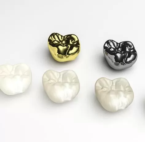 Custom dental crowns in shades of white, silver, and gold