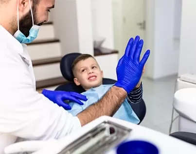 Hamilton dentist giving kid a high five after first teeth cleaning